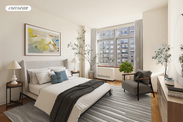 bedroom featuring radiator heating unit and wood-type flooring