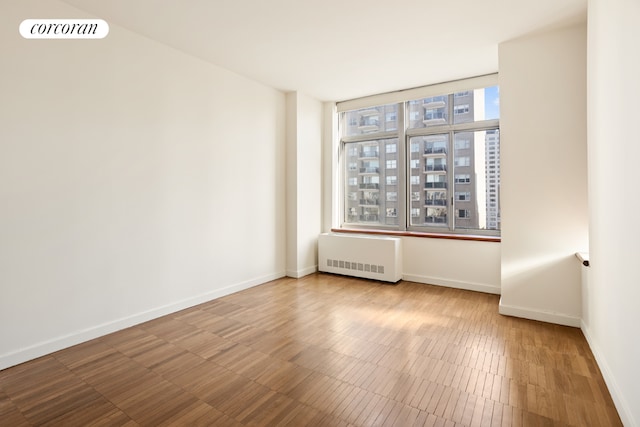 unfurnished room with radiator heating unit and plenty of natural light