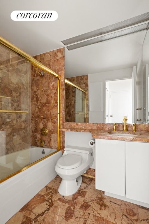 full bathroom with vanity, combined bath / shower with glass door, and toilet