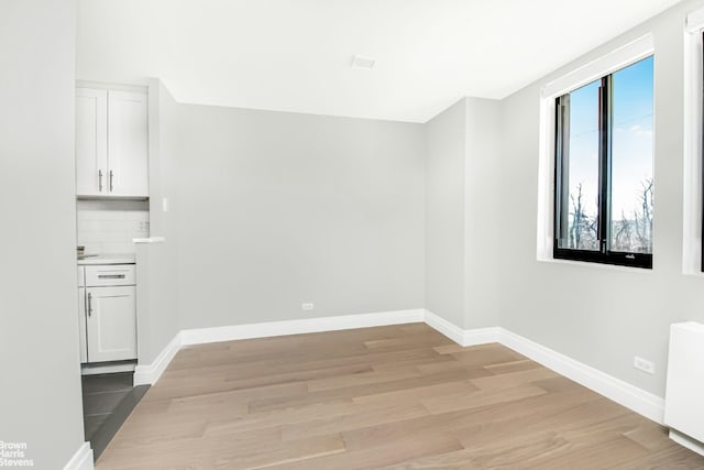 empty room featuring radiator heating unit and light wood-type flooring