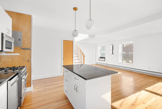 kitchen featuring white cabinets, stainless steel gas range, and decorative light fixtures