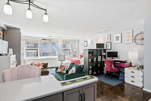 interior space with gray cabinetry, pendant lighting, track lighting, and dark parquet floors