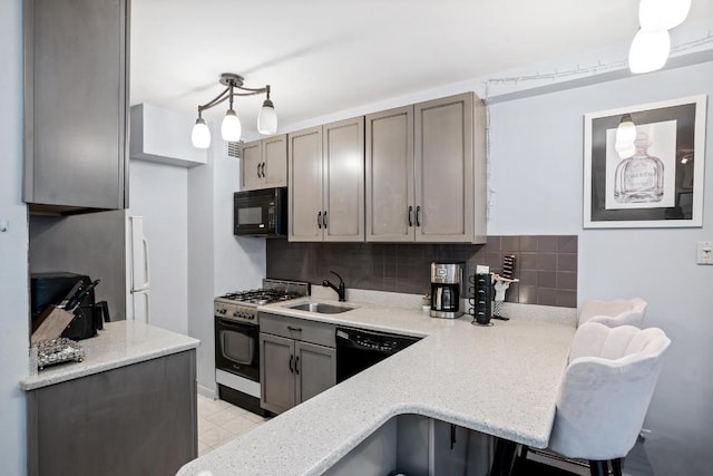 kitchen with sink, a kitchen breakfast bar, pendant lighting, decorative backsplash, and black appliances