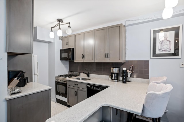 kitchen with a breakfast bar, decorative backsplash, a sink, a peninsula, and black appliances