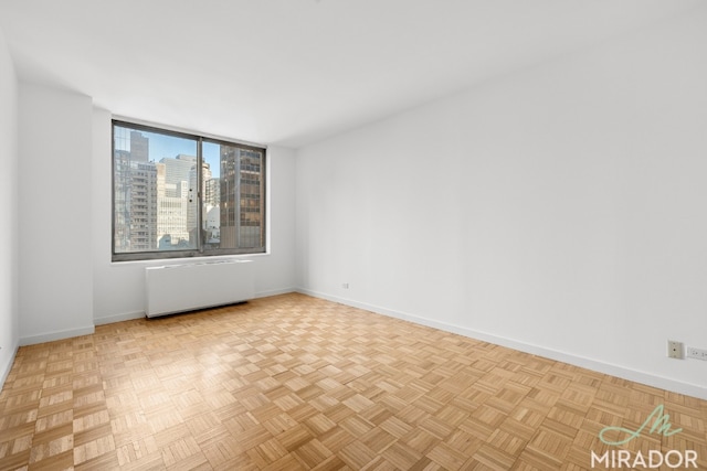 empty room featuring radiator and light parquet flooring