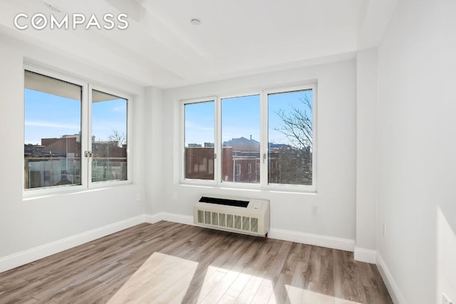 unfurnished room featuring heating unit and light wood-type flooring