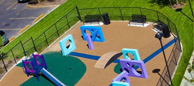 view of jungle gym featuring fence and a yard