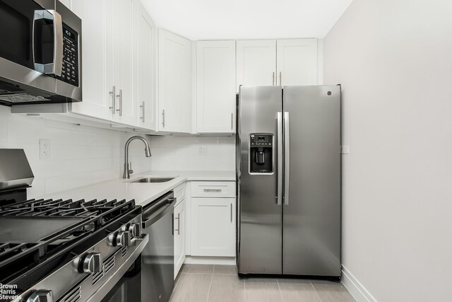 kitchen with white cabinetry, sink, decorative backsplash, and appliances with stainless steel finishes