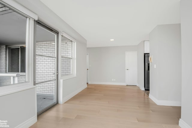 empty room featuring light wood-style flooring and baseboards