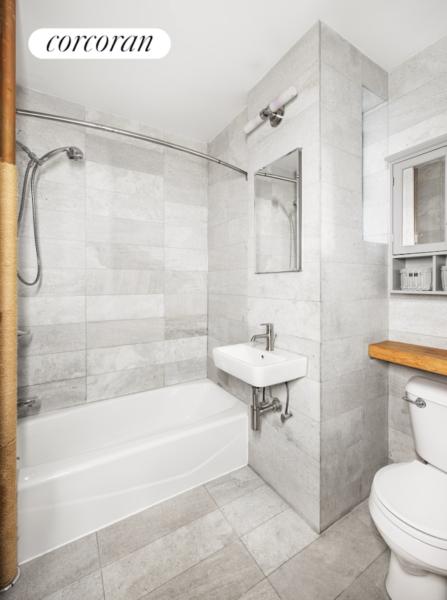 100 Suffolk St Unit 2E, New York City, NY 10002 - full bath featuring tile patterned floors, toilet, a sink, shower / bathtub combination, and tile walls