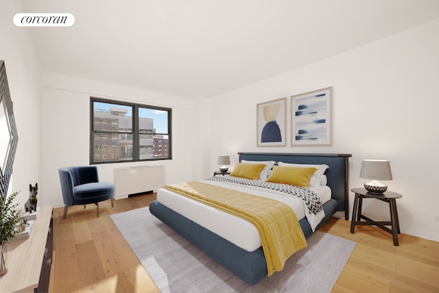 bedroom featuring wood finished floors, visible vents, and radiator