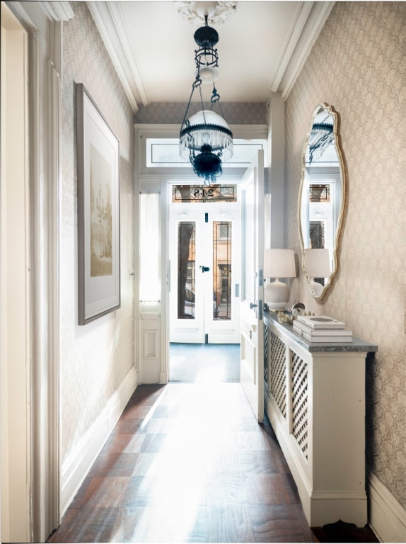 hall with hardwood / wood-style flooring, ornamental molding, and french doors