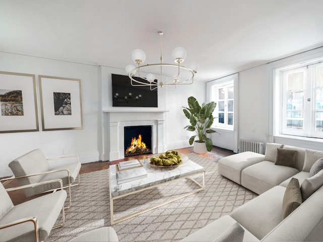 living room with a notable chandelier, radiator heating unit, and hardwood / wood-style floors