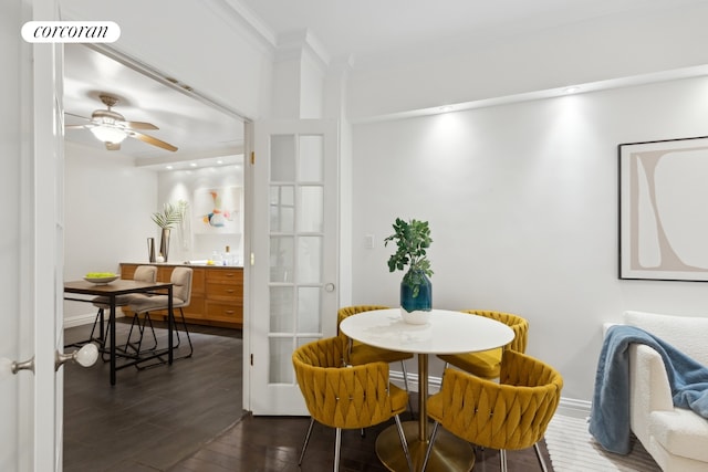 dining space featuring visible vents, baseboards, ornamental molding, dark wood-style floors, and a ceiling fan