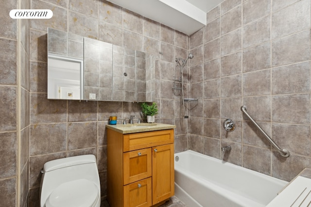 bathroom with toilet, vanity, shower / washtub combination, and tile walls