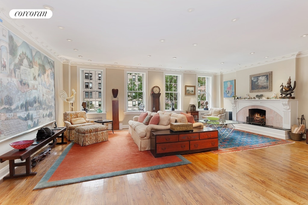 living room with light wood finished floors, visible vents, recessed lighting, and a high end fireplace