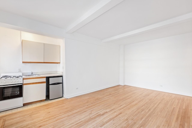 kitchen featuring light wood finished floors, white range with gas stovetop, light countertops, fridge, and beamed ceiling