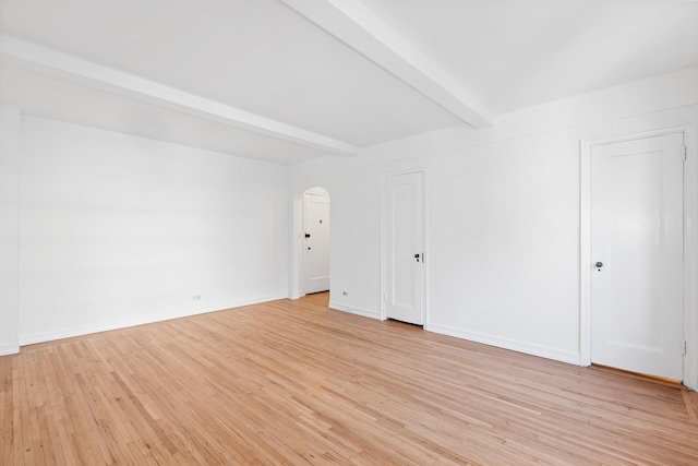 339 E 58th St Unit 7G, New York City, NY 10022 - unfurnished room with arched walkways, beamed ceiling, light wood-style flooring, and baseboards