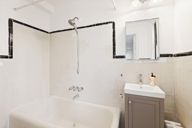 339 E 58th St Unit 7G, New York City, NY 10022 - full bath featuring vanity, bathtub / shower combination, tile walls, and a wainscoted wall