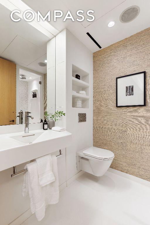 bathroom featuring built in shelves, toilet, and sink