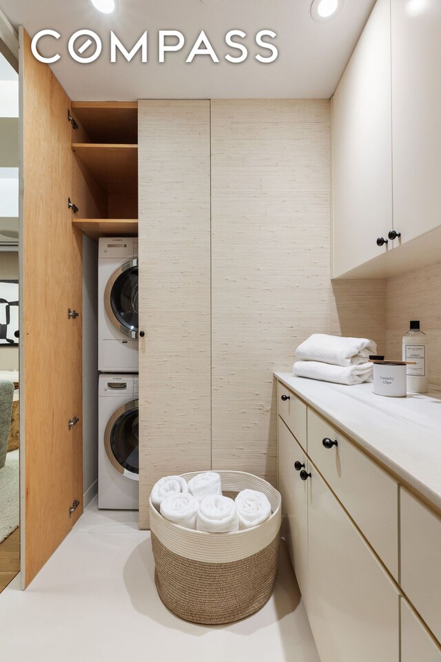 bathroom featuring stacked washer and dryer, vanity, and tile walls