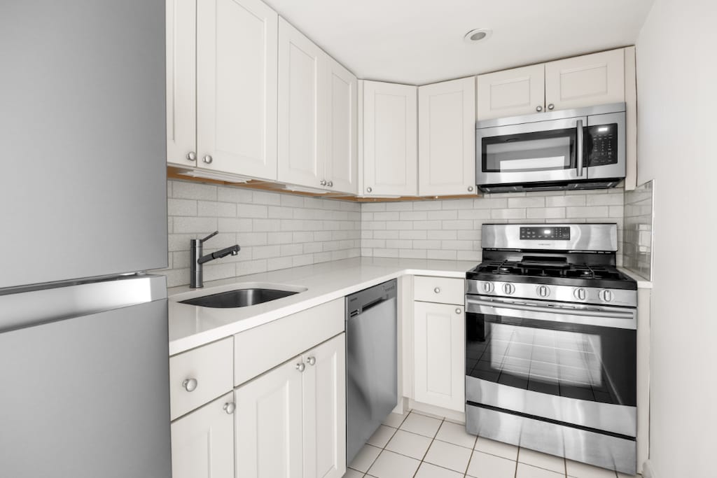 kitchen featuring tasteful backsplash, sink, white cabinets, and appliances with stainless steel finishes