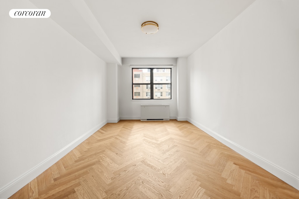 empty room with baseboards, radiator, and visible vents