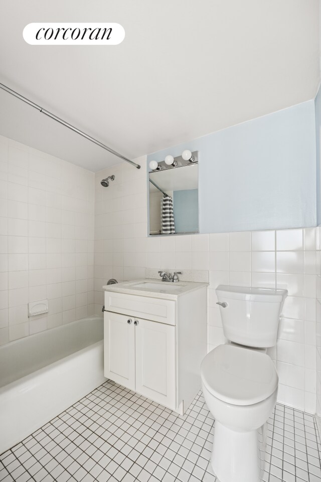 full bathroom featuring tile patterned flooring, vanity, tile walls, and toilet