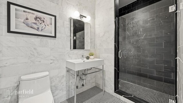 bathroom featuring sink, toilet, a shower with door, and tile walls