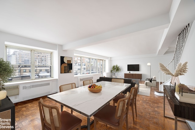 dining room featuring stairs, beamed ceiling, and radiator