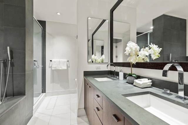 full bathroom featuring a sink, a stall shower, double vanity, and tile patterned flooring