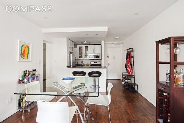 dining space with dark hardwood / wood-style flooring and sink