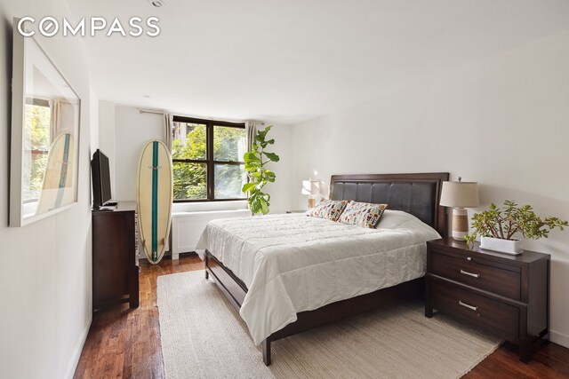 bedroom with dark wood-type flooring