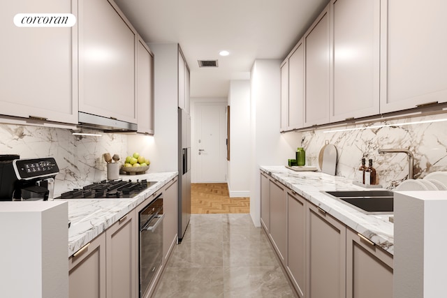 kitchen with light stone counters, visible vents, a sink, oven, and under cabinet range hood