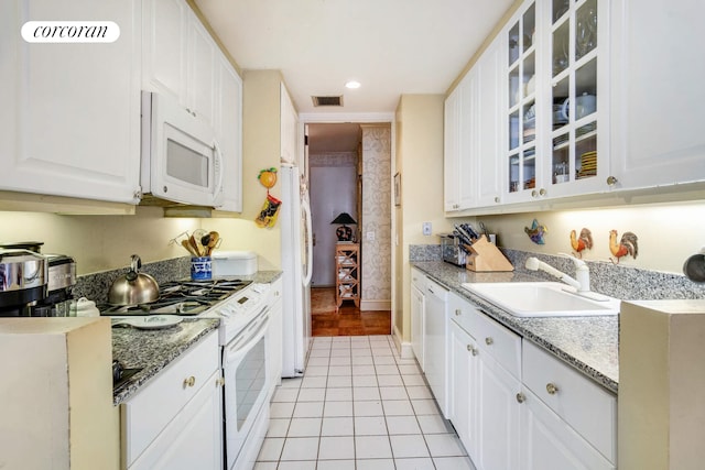 kitchen with visible vents, a sink, white appliances, light tile patterned flooring, and white cabinets