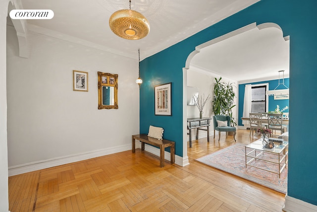 hall featuring arched walkways, visible vents, crown molding, and baseboards