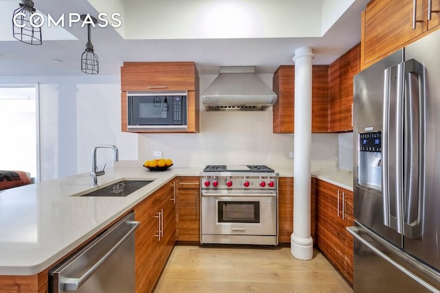 kitchen with brown cabinets, wall chimney exhaust hood, modern cabinets, and stainless steel appliances