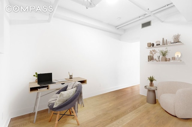 home office featuring visible vents, baseboards, and wood finished floors