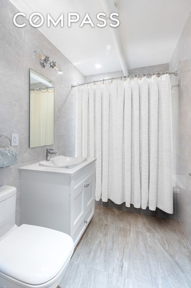 133 Mulberry St Unit 5A, New York City, NY 10013 - full bath featuring toilet, vanity, beamed ceiling, and shower / tub combo with curtain