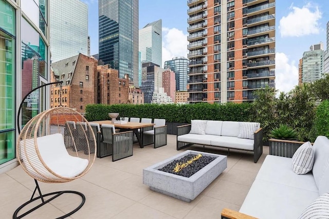 view of patio with an outdoor living space with a fire pit