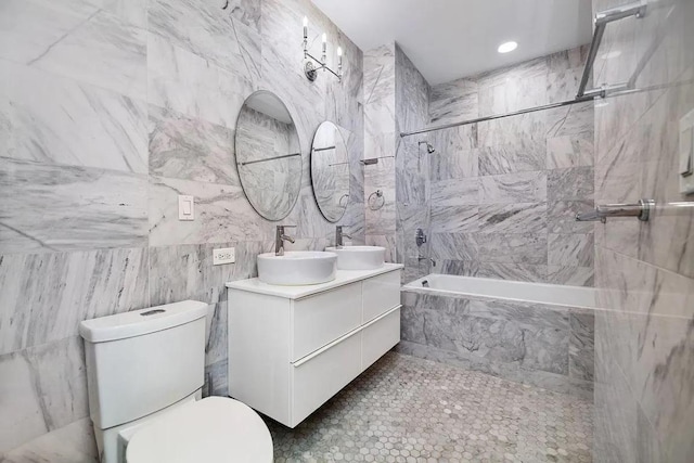 full bathroom featuring vanity, tile walls, toilet, and tiled shower / bath