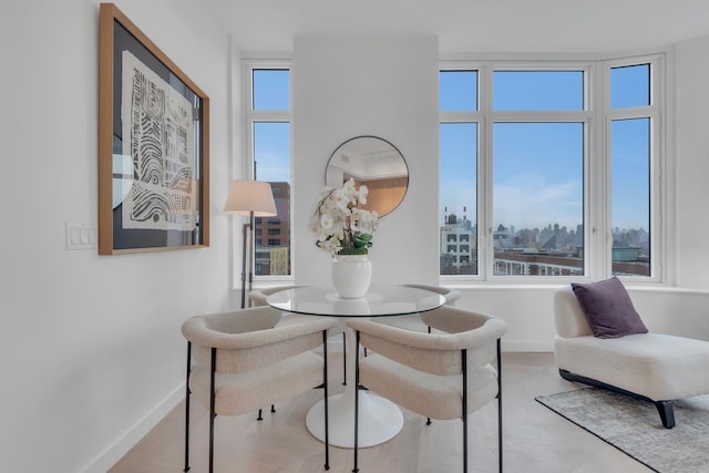 dining space featuring a view of city and baseboards