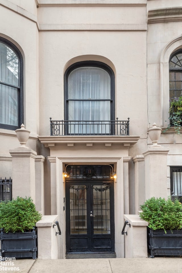 doorway to property with a balcony and french doors