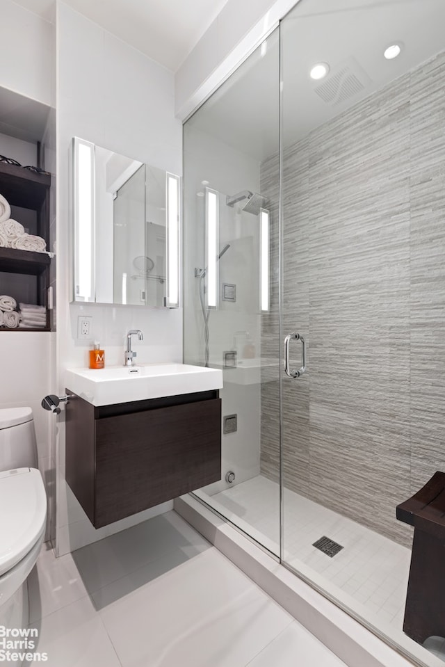 bathroom with a shower stall, toilet, tile patterned flooring, and vanity