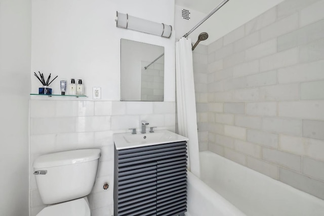 full bathroom with vanity, toilet, shower / tub combo, and tile walls