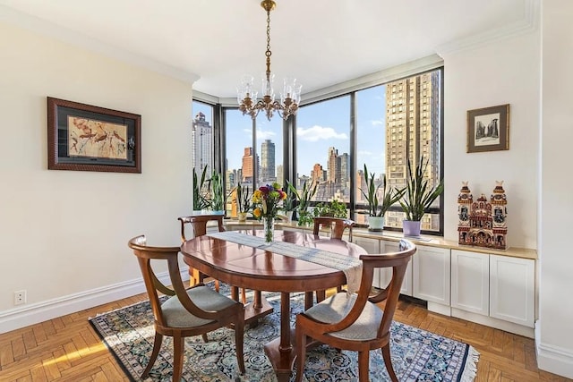 dining room with a chandelier, a city view, ornamental molding, and baseboards