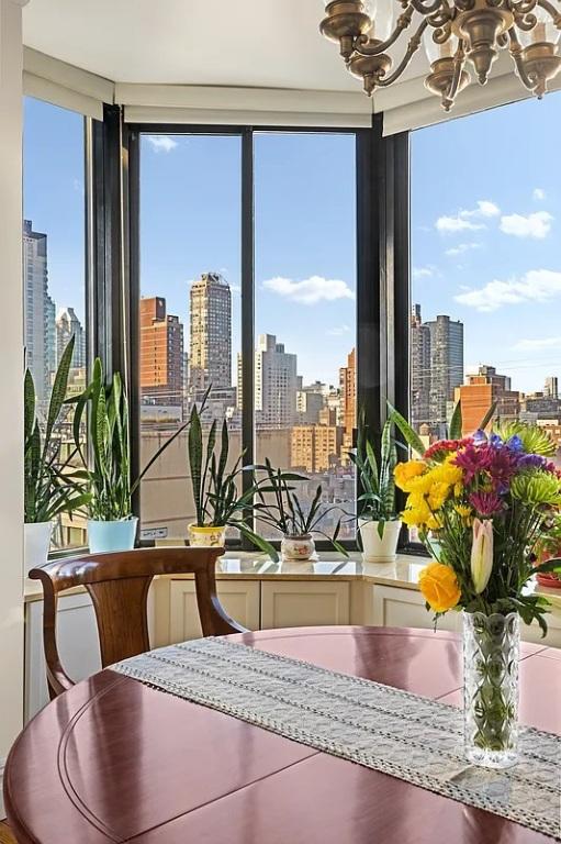 sunroom / solarium featuring a notable chandelier and a city view