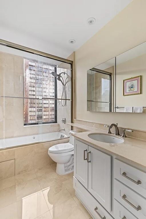 full bathroom with tiled shower / bath combo, vanity, and toilet