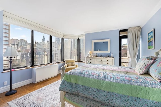 bedroom with a view of city, baseboards, and crown molding