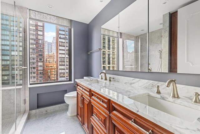 full bath with a view of city, double vanity, a stall shower, and a sink